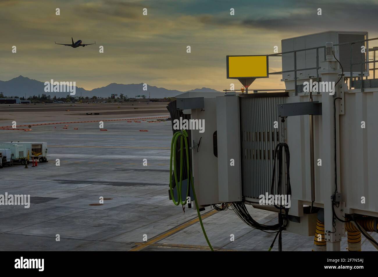 Aeroporto Sky Harbor al tramonto con l'aereo che decollo sul ponte di imbarco utilizzato per collegare l'aeroporto a Phoenix, Arizona USA Foto Stock