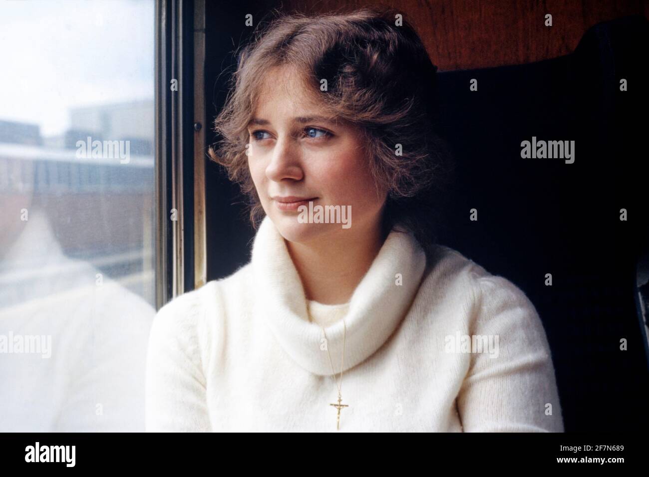 bella donna ben vestita che guarda fuori dalla carrozza del treno finestra durante il viaggio verso la destinazione turistica all'inizio degli anni '80 inghilterra regno unito Foto Stock