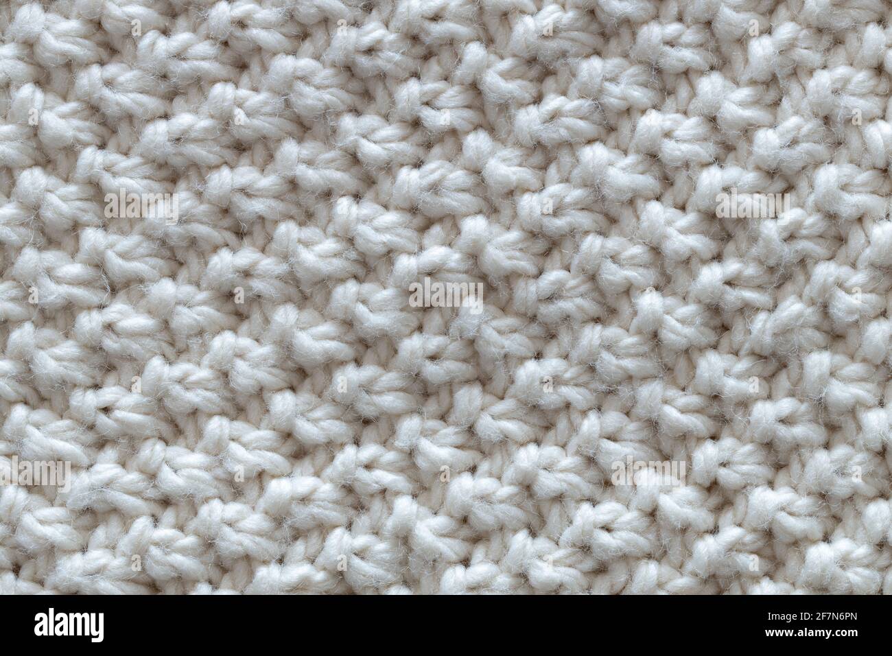Sfondo da sfondo bello, lavorato a maglia, motivo noduli. Concept artigianato, fai da te, tempo libero, abiti caldi alla moda, hobby. Vista dall'alto, macro, Foto Stock