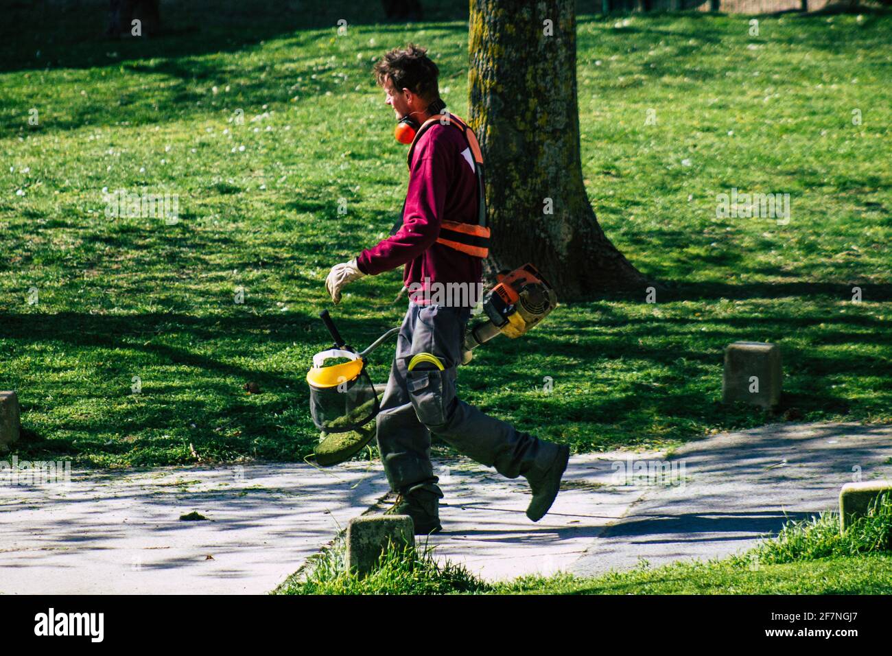 Reims Francia 08 aprile 2021 Gardener con un rasaerba manuale in primavera in un parco pubblico nella città di Reims in Francia Foto Stock