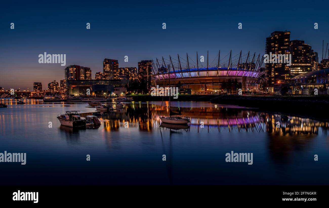 Vancouver Skyline di notte con il BC Place Stadium illuminato di notte presso la North Shore di False Creek Inlet, British Columbia, Canada Foto Stock