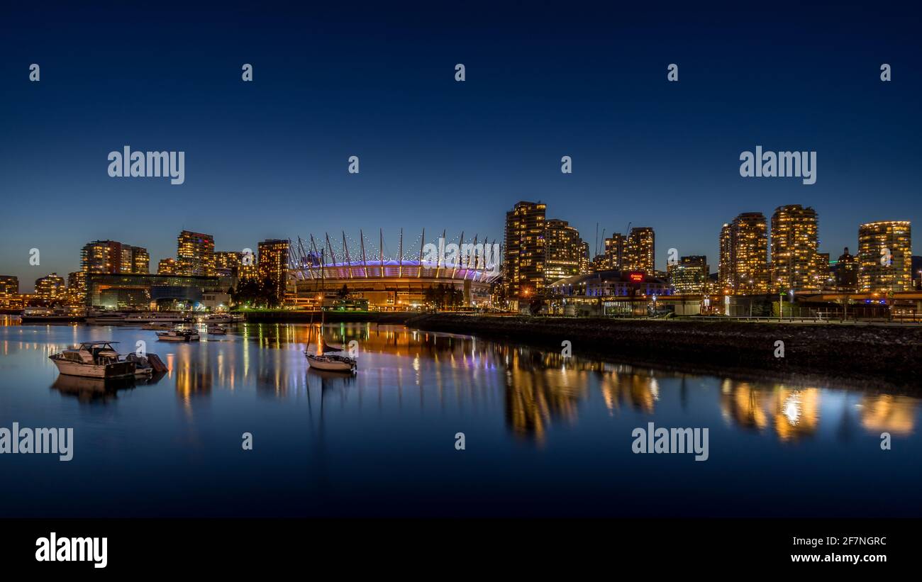 Vancouver Skyline di notte con il BC Place Stadium illuminato di notte presso la North Shore di False Creek Inlet, British Columbia, Canada Foto Stock
