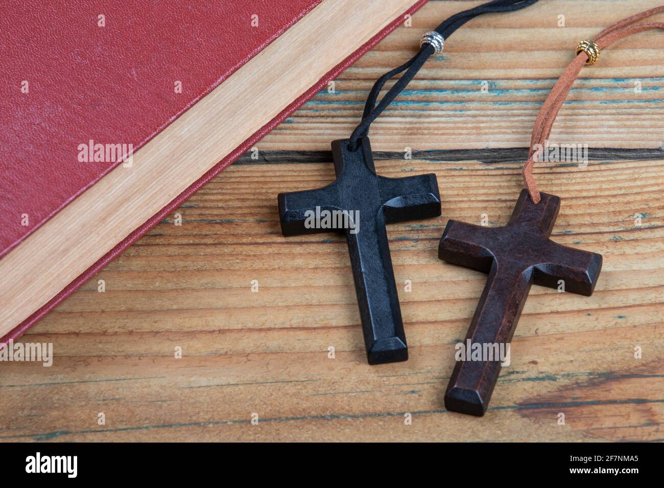 Libro e due croci di legno su un tavolo di legno. Fede, credo e concetto di salute mentale. Foto Stock