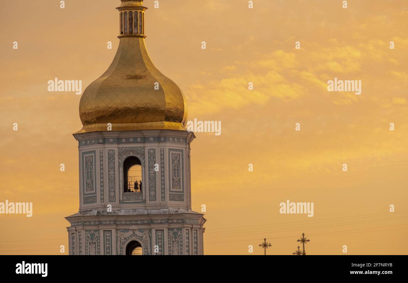 Guglia della Cattedrale di Sofia al tramonto a Kiev. Due persone sono in cima alla torre. Foto Stock