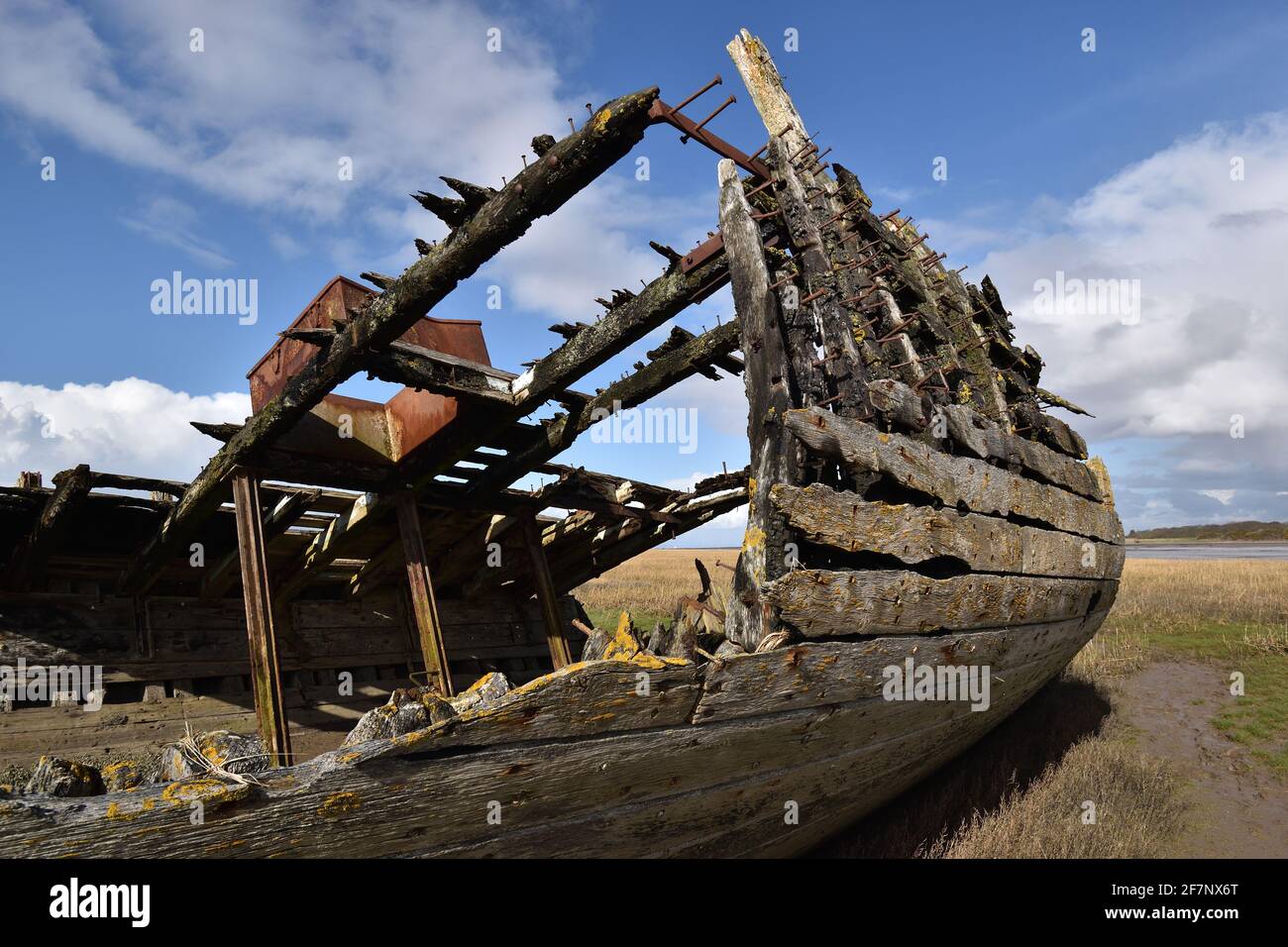 Relitto situato sulle pianure di fango del fiume Wyre, Fleetwood. Un ricordo della fiorente industria della pesca cittadina, che viene lentamente recuperato dal fango. Foto Stock