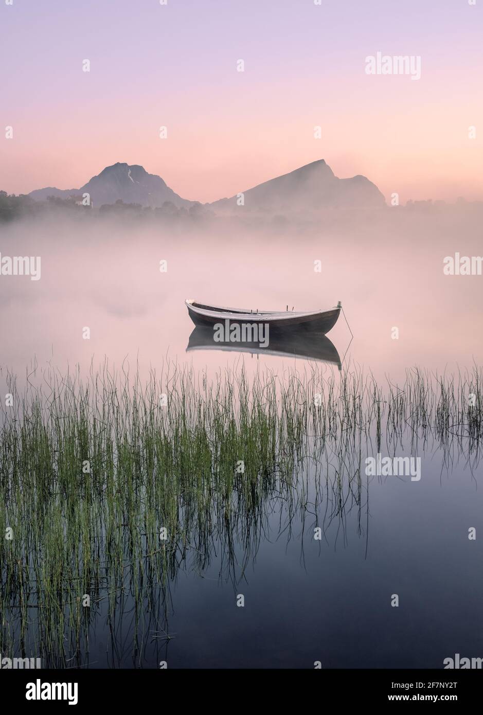 Molto tranquillo la notte d'estate con la barca di legno e la nebbia in Lofoten, Norvegia Foto Stock