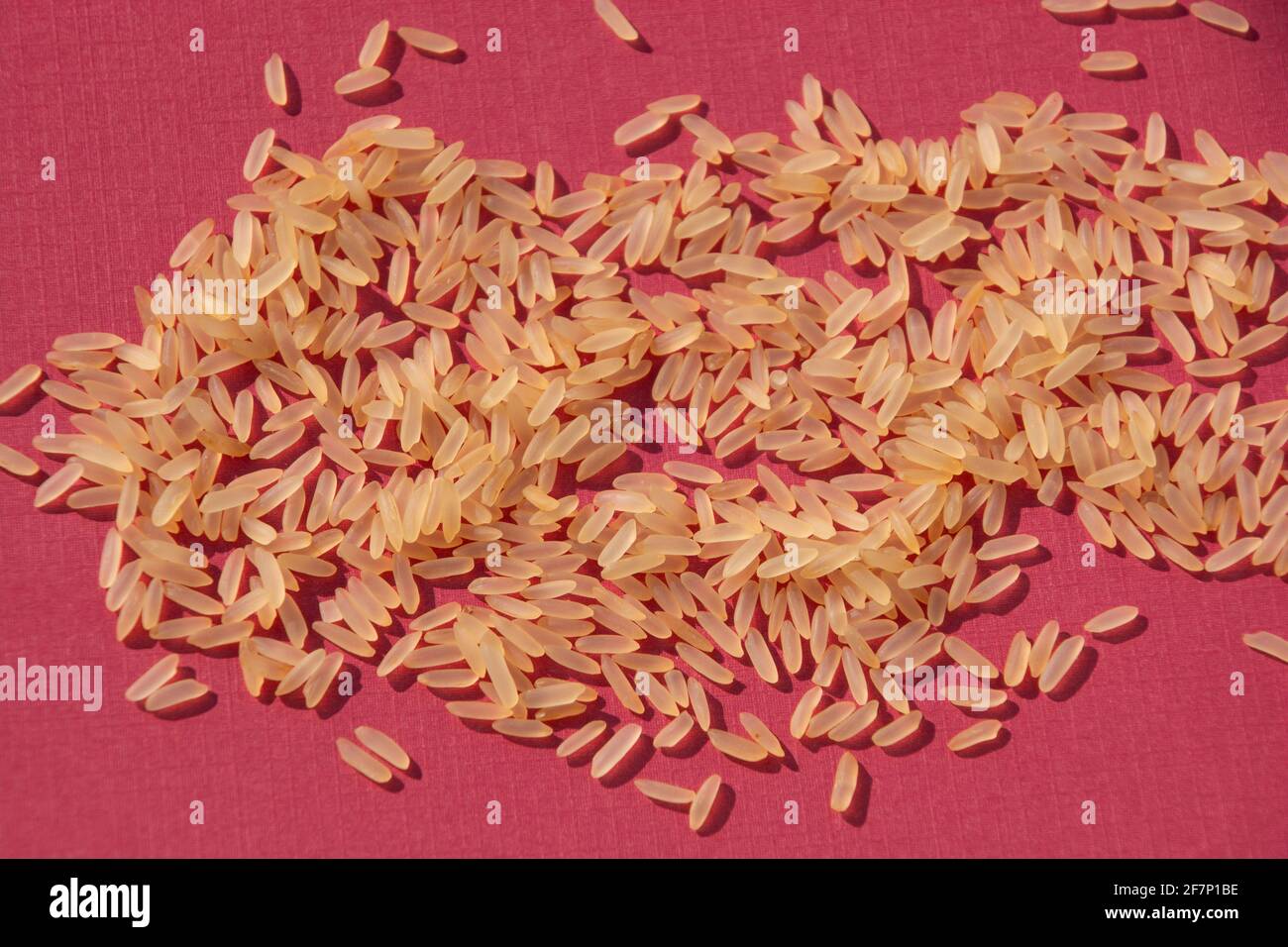 mucchio crudo di riso parboiled sul tema vegetariano di foglio di carta colorato Foto Stock