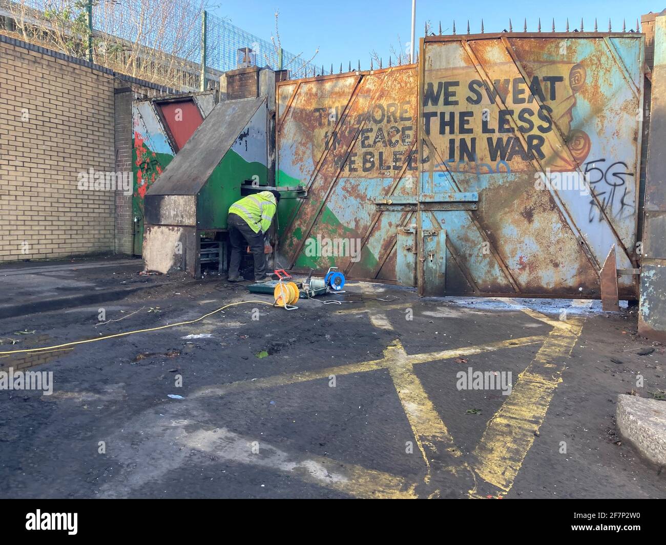 Un'operazione di pulizia in corso a Lanark Way, nell'ovest di Belfast, seguendo scene di violento disordine nelle ultime notti. I lavori di riparazione sono stati eseguiti su un cancello del muro di pace, nella foto, che separava le comunità lealista e repubblicana dopo che era stata messa in fuoco durante le saccheggi. Data immagine: Venerdì 9 aprile 2021. Foto Stock