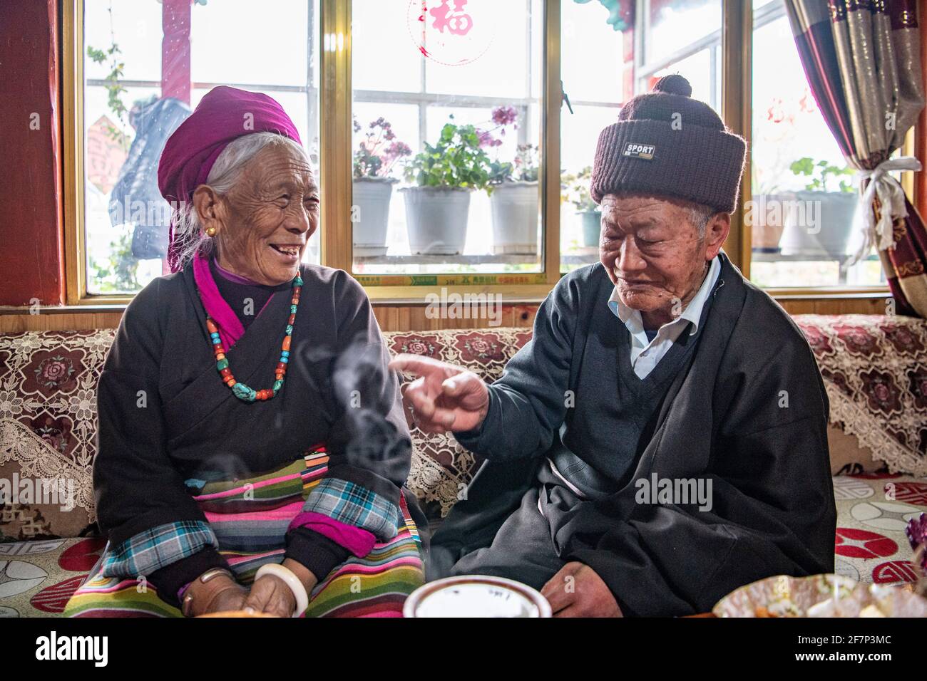 (210409) -- LHASA, 9 aprile 2021 (Xinhua) -- Ngawang Nyima chiacchiera con sua moglie nella loro residenza a Qamdo City, regione Autonoma del Tibet della Cina sudoccidentale, 18 febbraio 2021. Ngawang Nyima, 84 anni, è nato a Naixi Township, nella contea di Mangkam, nella città di Qamdo, nella regione autonoma del Tibet della Cina sudoccidentale, ed era un serf. Carico di pesanti tasse, iniziò a gregge di pecore per i padroni di casa quando non aveva più di otto anni, e fu costretto a prelevare il bittero da una salina del fiume Lancang. Il sentiero per la saliera era così precipitoso che un singolo passo incauto ne avrebbe rovesciato uno in rapide onde nel rive Foto Stock