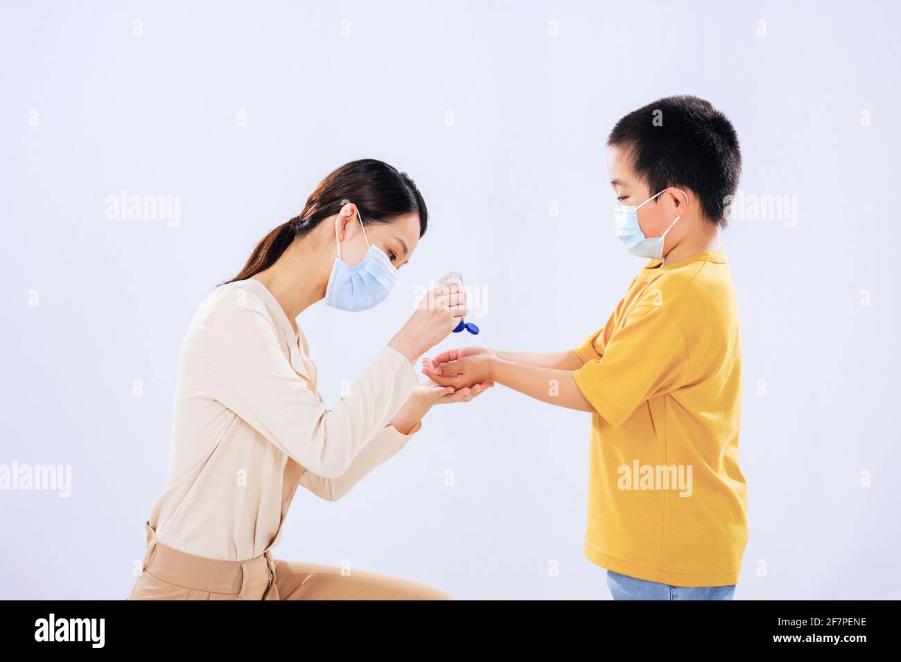 La madre insegnò al ragazzino ad usare l'igienizzatore per le mani con la mamma Foto Stock
