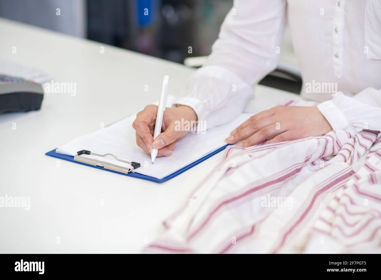 Le mani femminili scrivono con la penna sul foglio Foto Stock