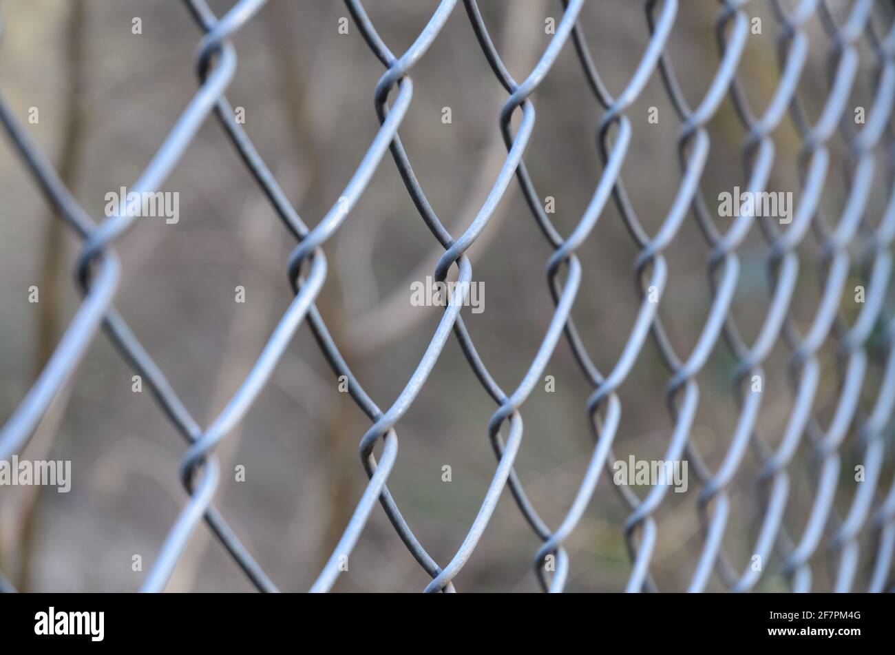 Primo piano di recinzione metallica a catena, modello a diamante, con profondità di campo ridotta o messa a fuoco selettiva, sfondo astratto o sfondo Foto Stock