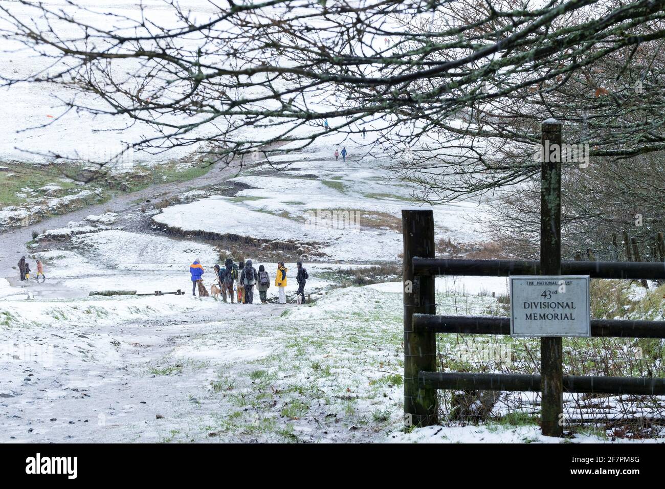 Le persone che si godono una passeggiata nella neve su Rough Tor su Bodmin Moor in Cornovaglia. Foto Stock