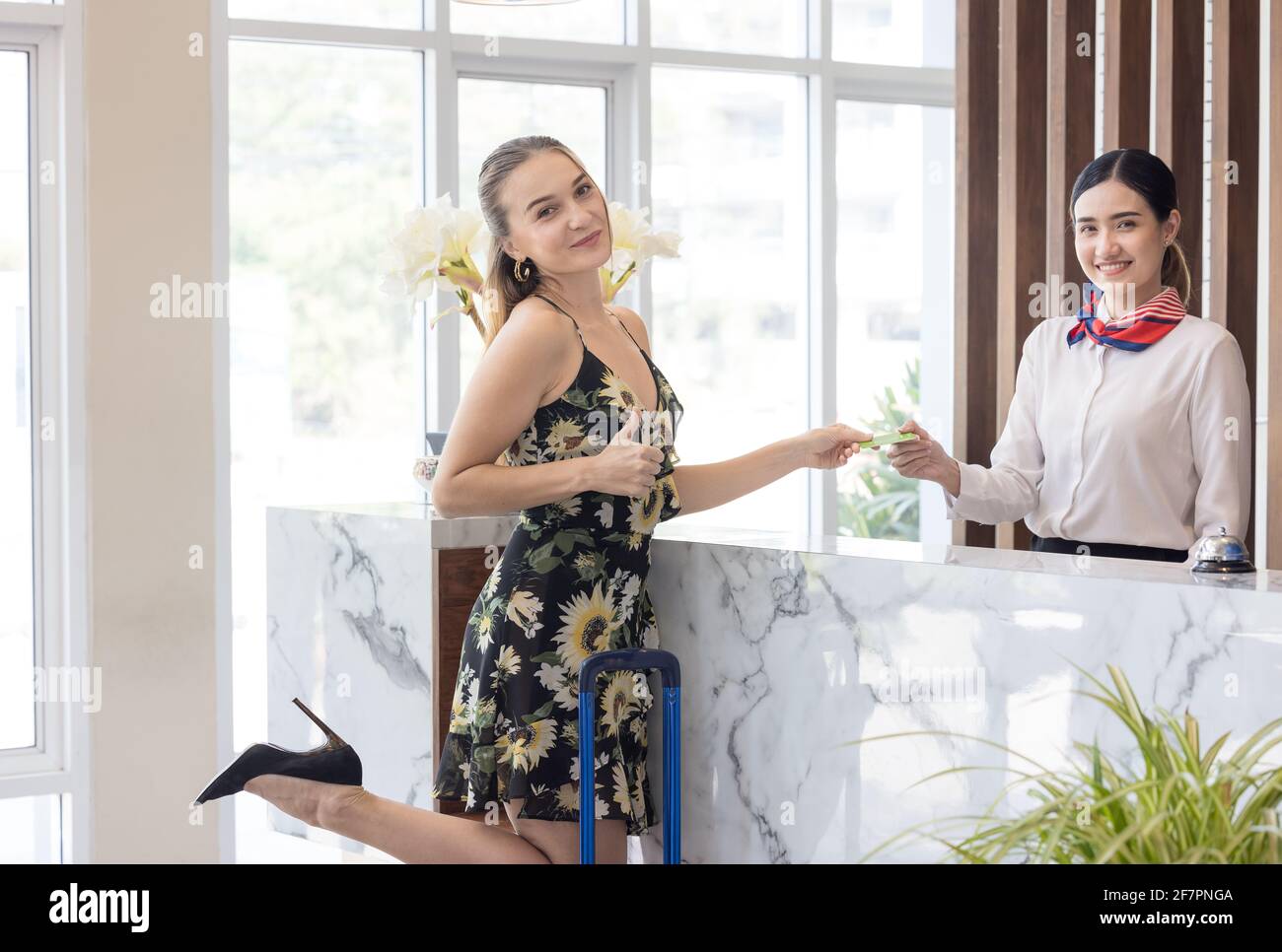 Gli ospiti effettuano il pagamento con carta di credito per i servizi al banco di check-in dell'hotel, clienti che effettuano il check-in in presso un resort Foto Stock
