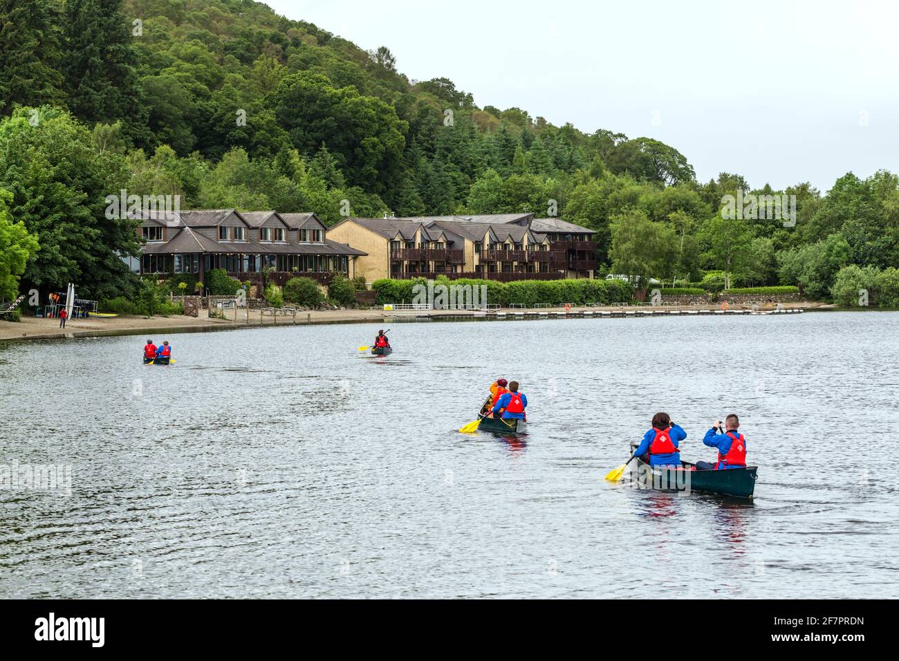 Persone in kayak verso l'hotel Lodge on Loch Lomond nel Loch Lomond e Trossachs National Park, Luss, Scozia, Regno Unito Foto Stock