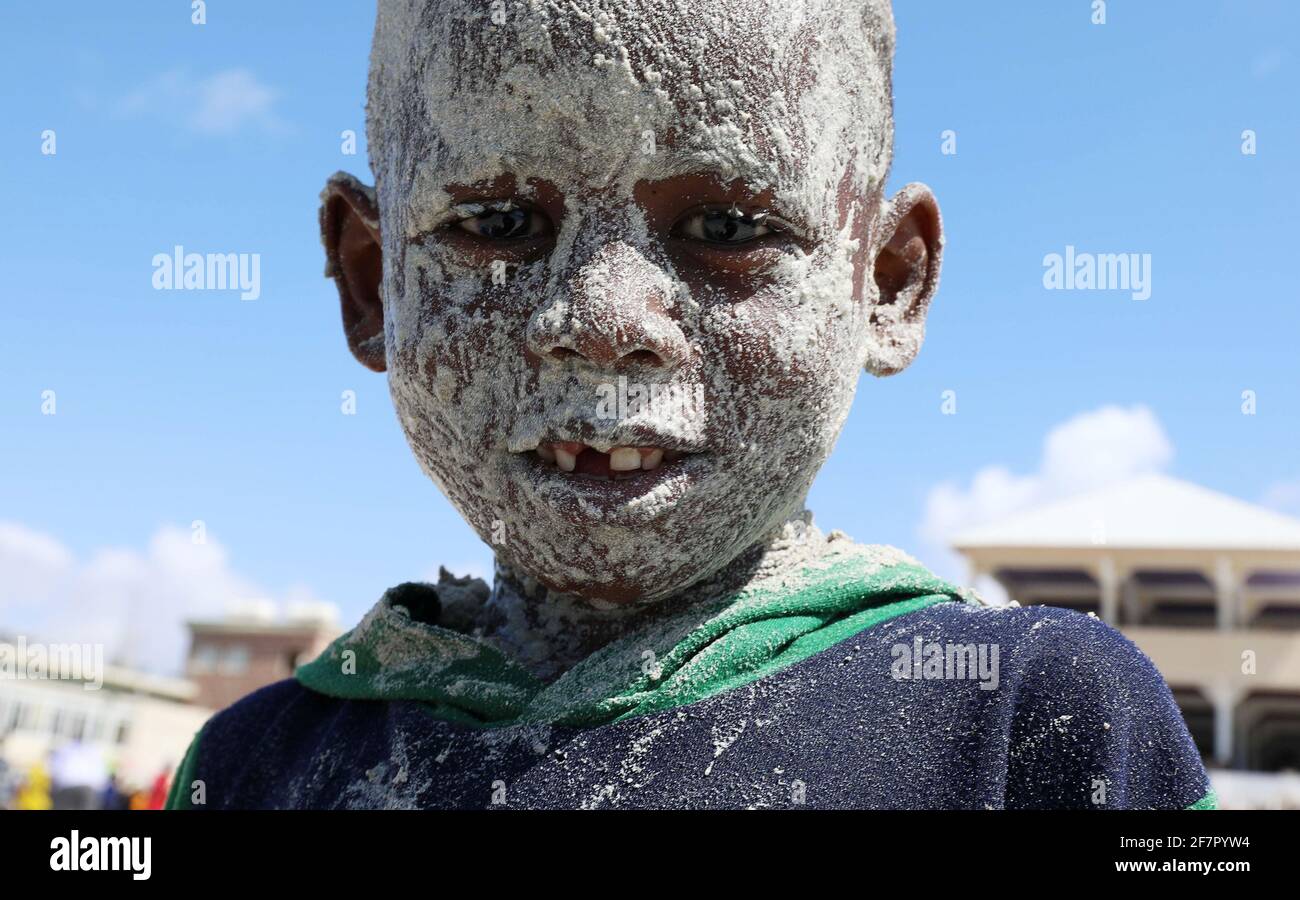 Un ragazzo somalo copre il suo volto con la sabbia alla spiaggia di Liido durante l'ultimo venerdì, in vista del mese santo musulmano del Ramadan, in mezzo alla malattia del coronavirus (COVID-19) pandemia a Mogadiscio, Somalia 9 aprile 2021. OMAR REUTERS/Feisal Foto Stock