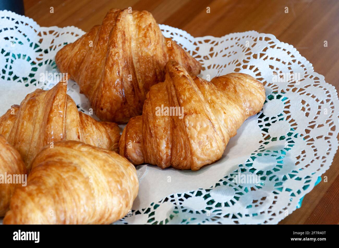 Buon concetto di mattina. Croissant appena sfornati su un piatto con tovagliolo. Croissant e panini appena sfornati Foto Stock