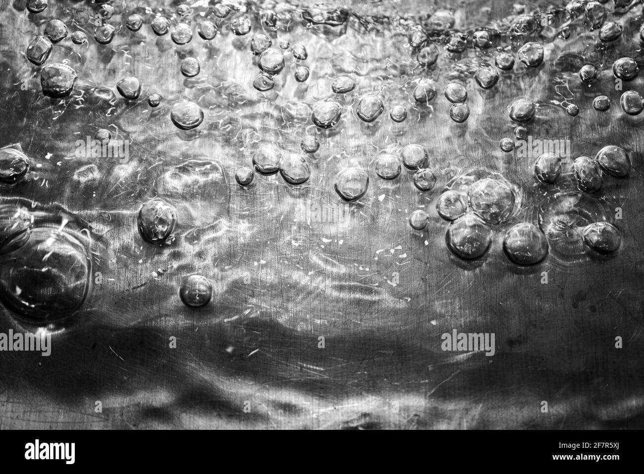 Ripresa macro di molte bolle su una superficie metallica lucida Foto Stock
