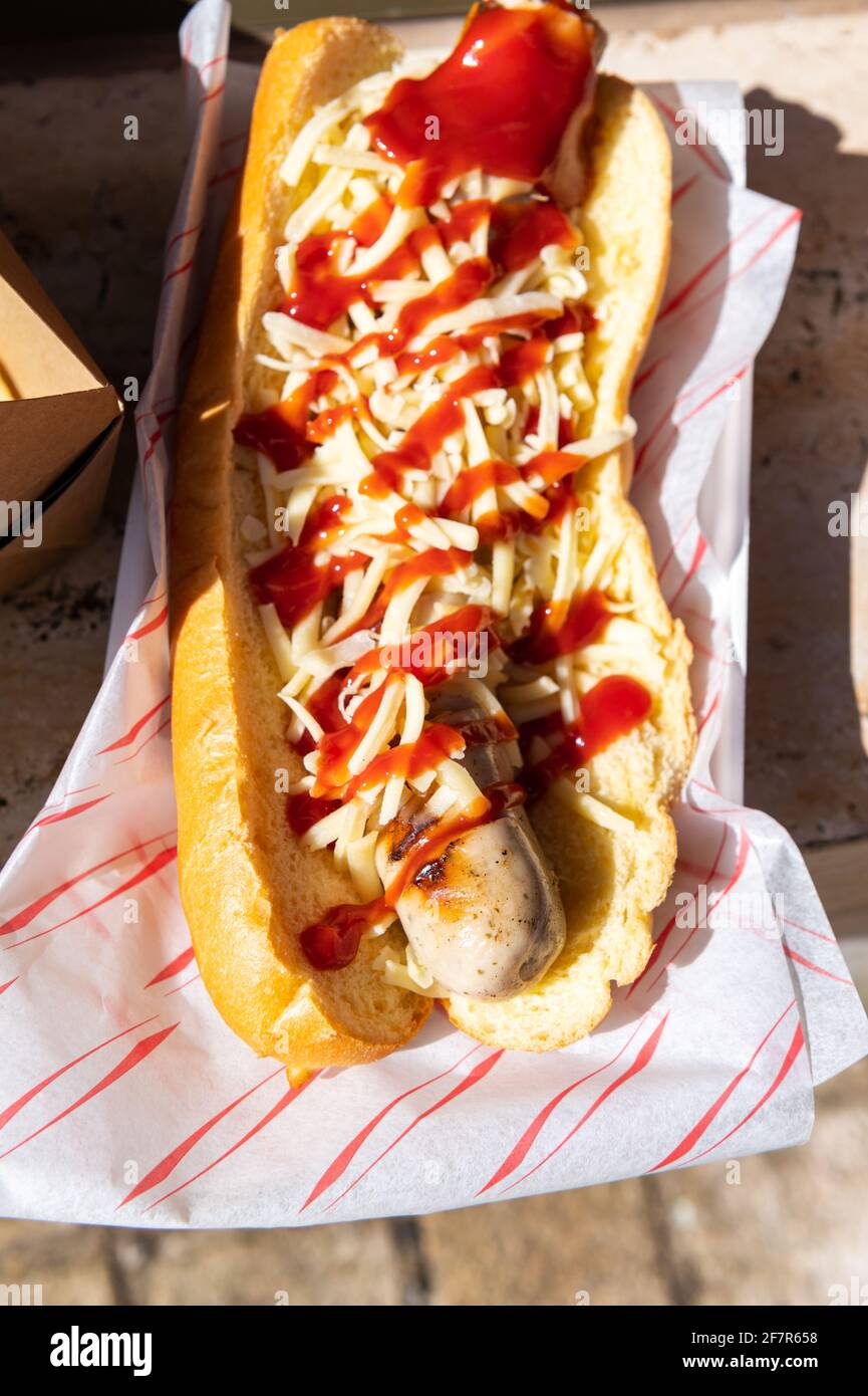 La ragazza sta tenendo take away Cheese Hot Dog Foto Stock