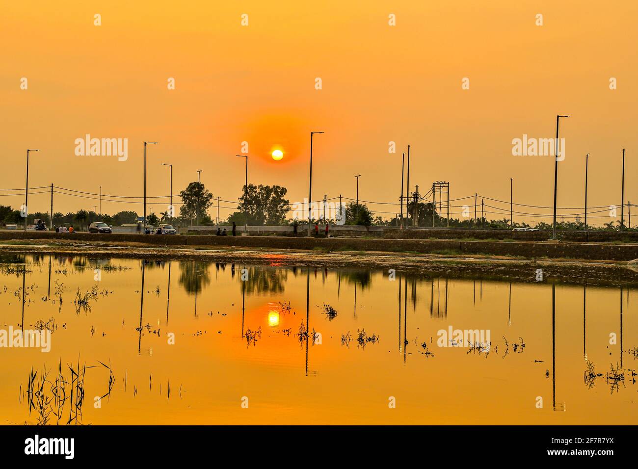 bel sole tramontato all'ora d'oro con riflesso in acqua. Foto Stock