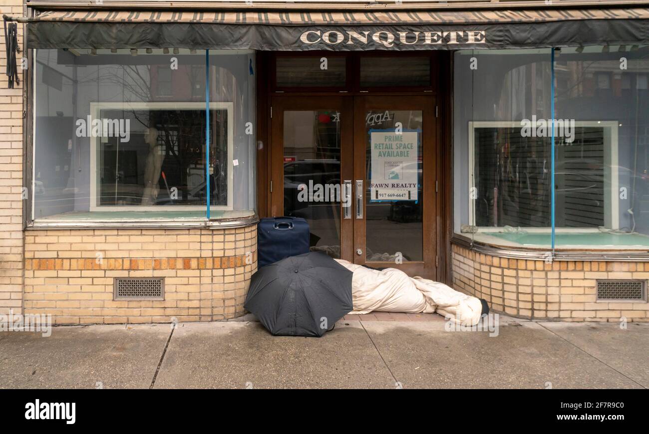Un individuo senzatetto dorme di fronte ad un deposito vacante a New York domenica 28 marzo 2021. (© Richard B. Levine) Foto Stock