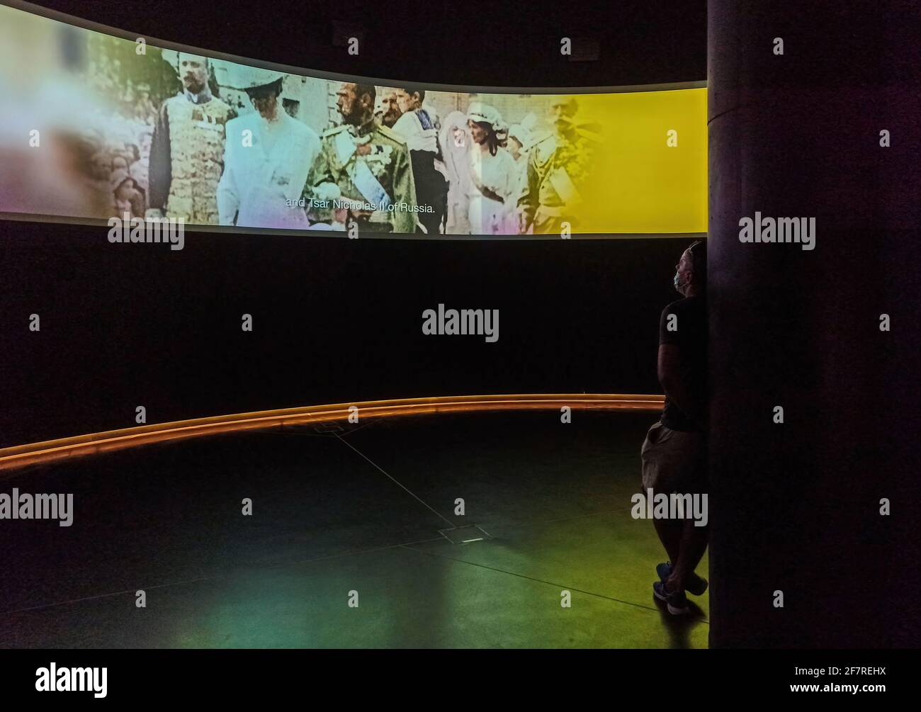 GDANSK, POLONIA - 10 agosto 2020: Un uomo in maschera protettiva in piedi in una sala cinematografica che guarda gli eventi storici legati alla guerra mondiale nel museo Foto Stock