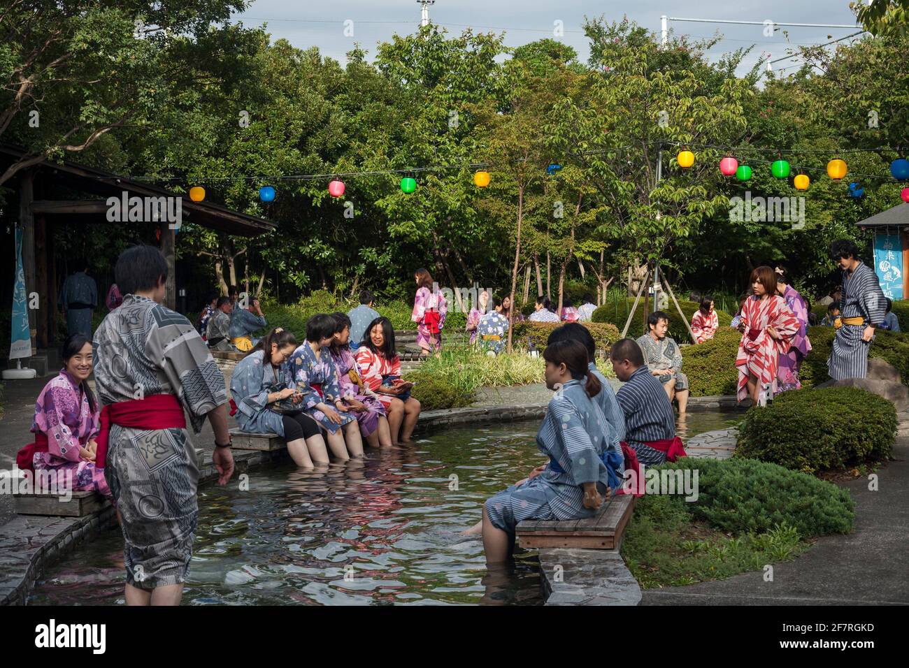 Vista orizzontale di un gruppo di persone che indossano yukata immergersi e rilassarsi in Oedo-Onsen Monogatari all'aperto rotenburo bagni, Koto City, Odaiba Island Foto Stock