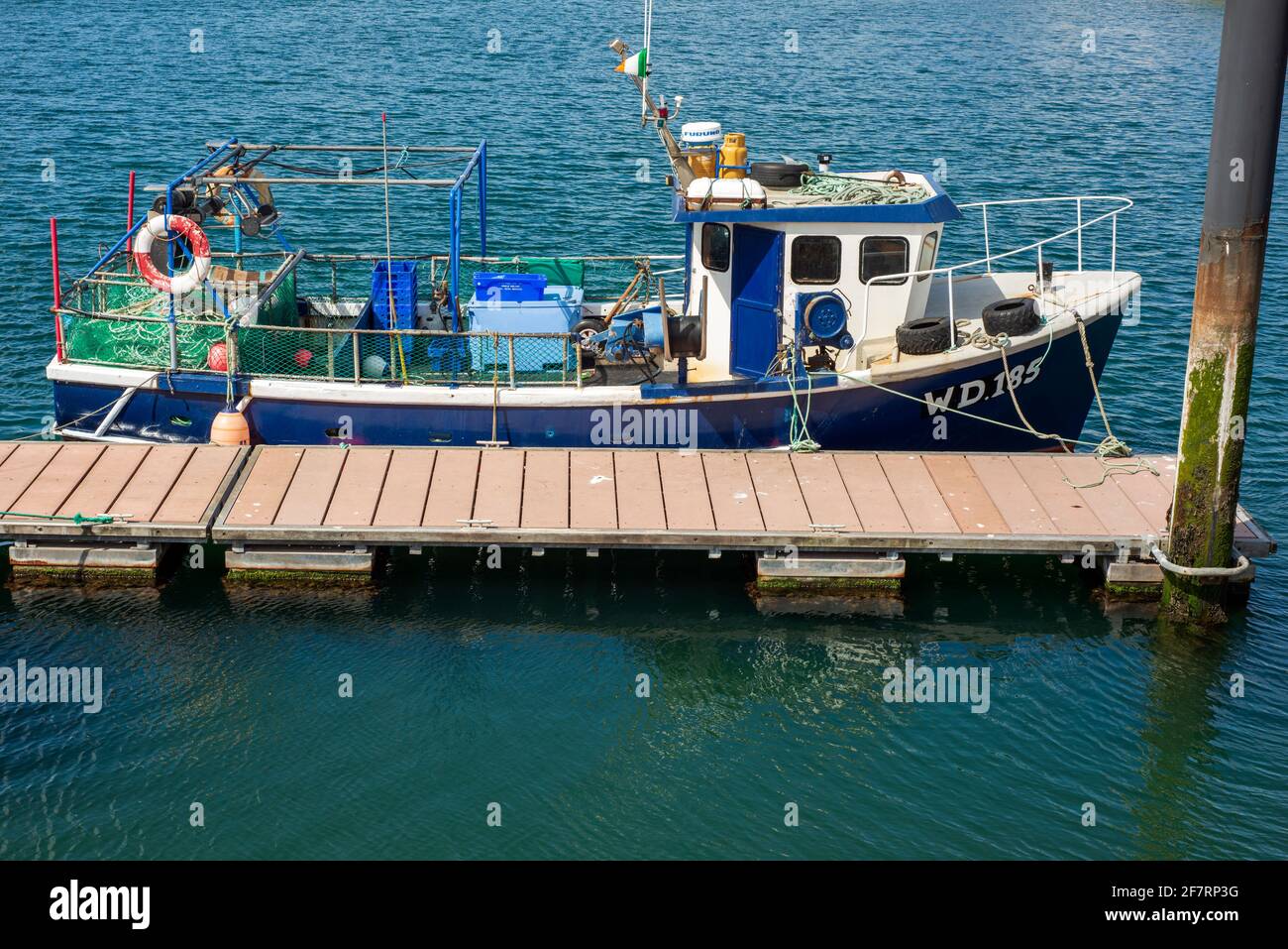 Imbarcazione da pesca blu con bandiera irlandese ormeggiata nel porto e porto turistico di Dingle, contea di Kerry, Irlanda Foto Stock