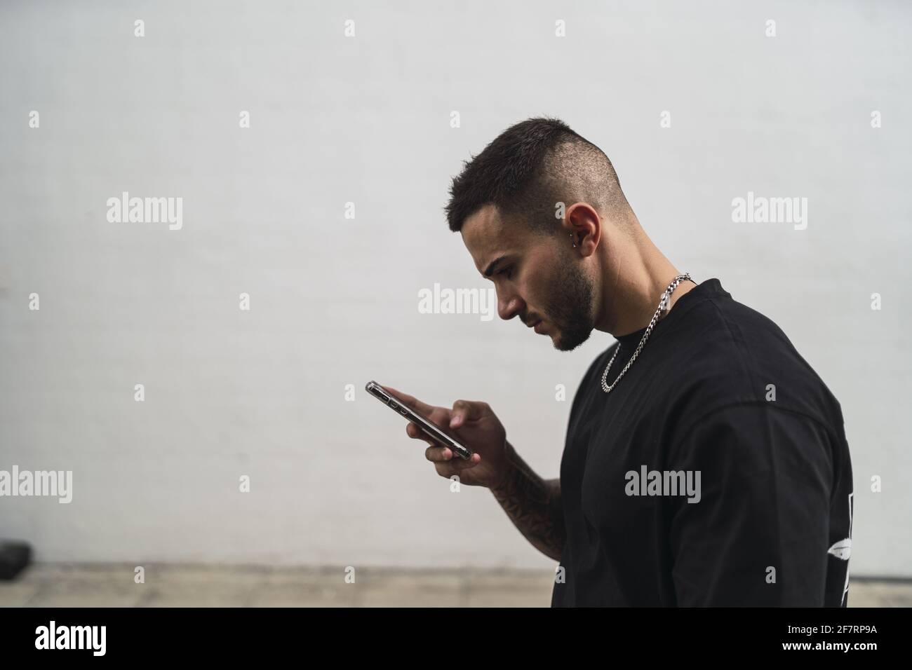 Spagnolo maschio utilizzando un telefono all'aperto Foto Stock