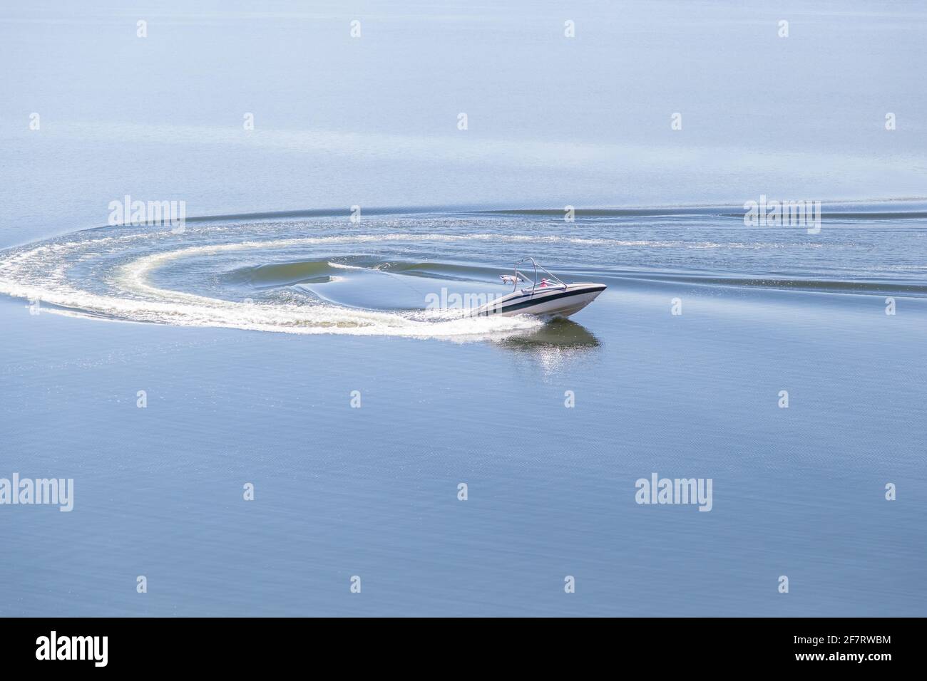 Speed Boat U-turn su un lago di vetro su un soleggiato giorno Foto Stock
