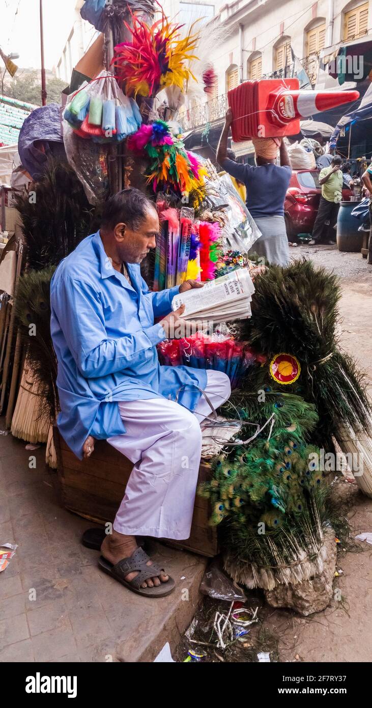 Kolkata, Bengala Occidentale, India - Gennaio 2018: Un venditore di strada che vende piume di pavone e altri articoli da regalo assortiti al suo negozio per le strade del c. Foto Stock