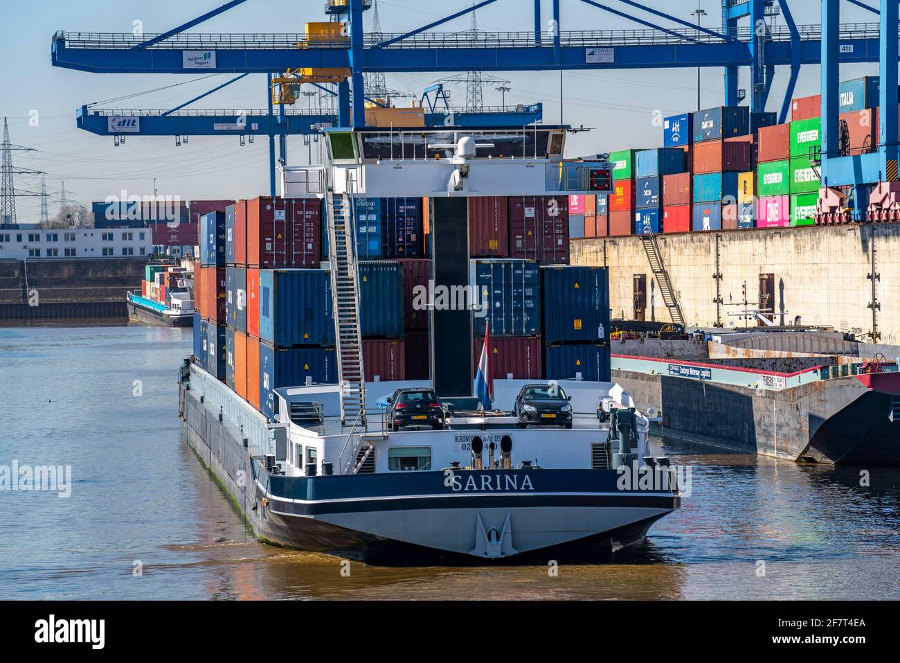 La nave di carico del container entra nel bacino portuale del Logport, le gru a portale nel centro di movimentazione dei container, il terminal dei container trimodale, presso il Logp Foto Stock