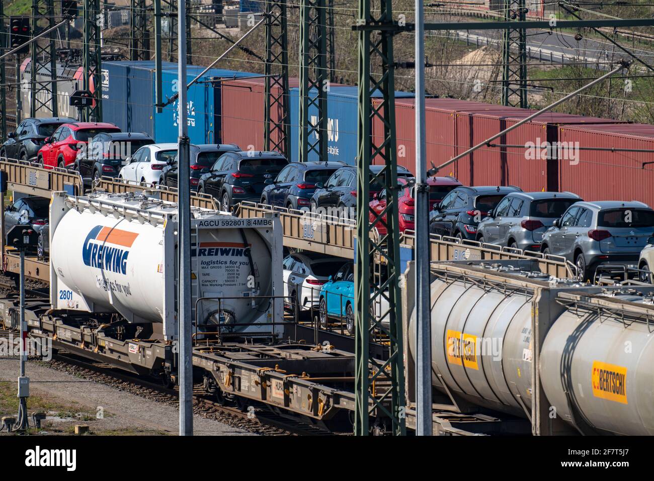 Stazione di trasporto di Duisburg-Rheinhausen, nella zona portuale di Logport, treni merci caricati con auto nuove, serbatoi vari e il treno container da Foto Stock
