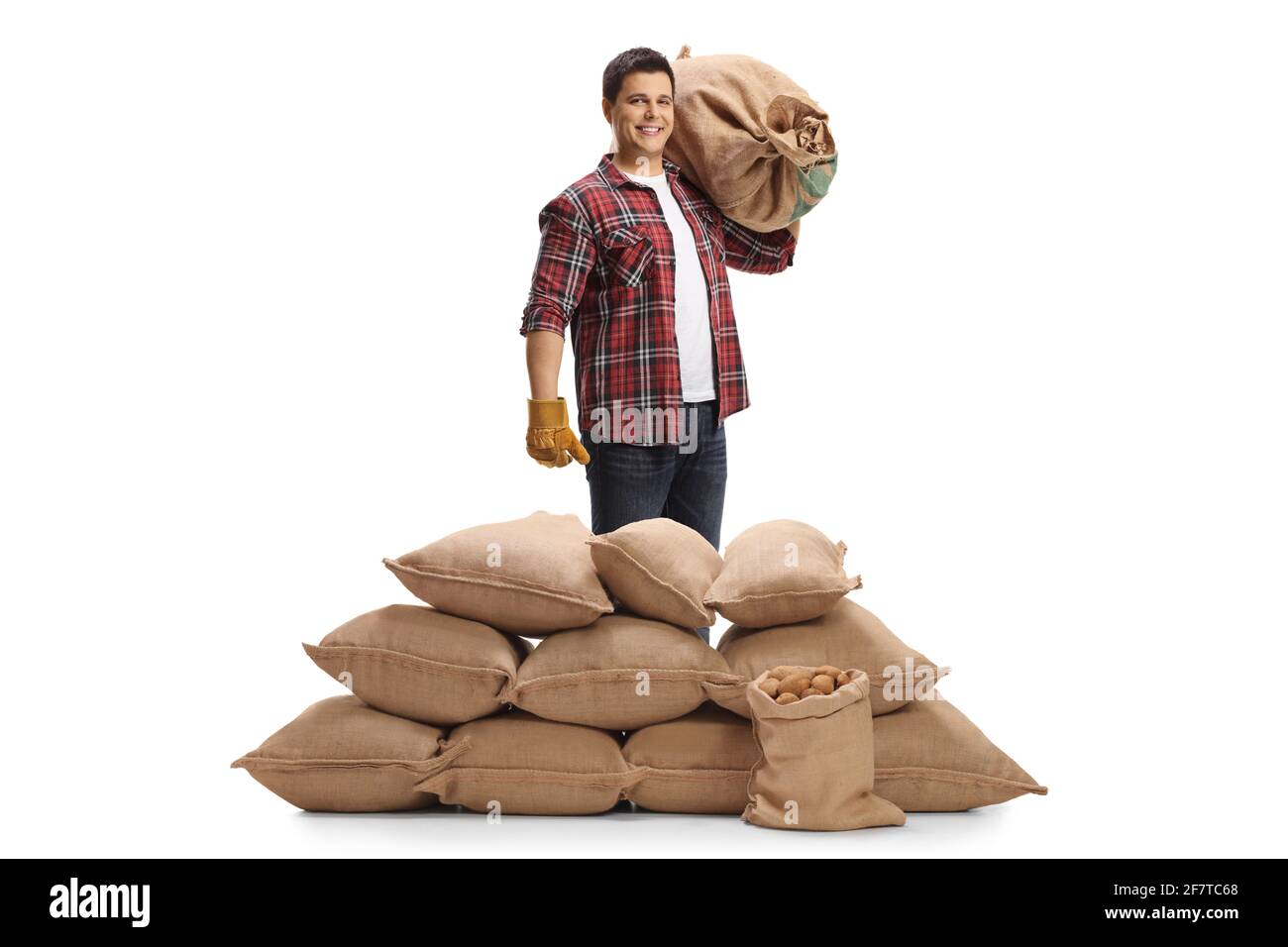 Ritratto a lunghezza intera di un coltivatore con un mucchio di sacchi con patate isolate su sfondo bianco Foto Stock