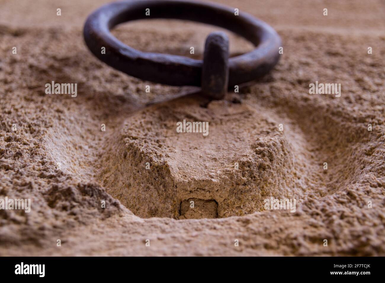 Dettaglio di un vecchio anello di ferro arrugginito appeso su un muro di pietra Foto Stock