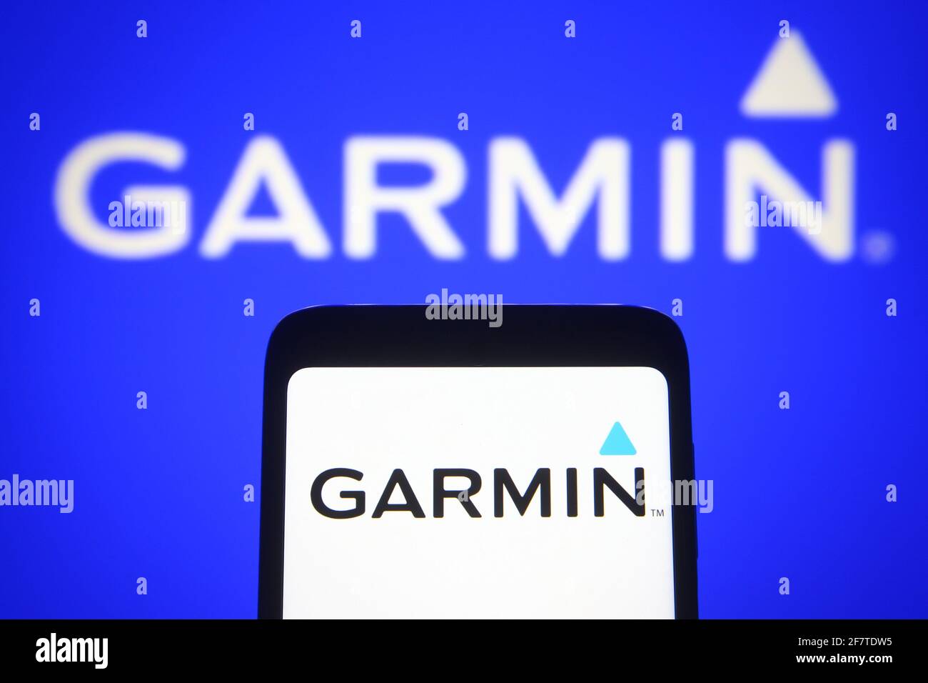 In questa illustrazione fotografica il logo Garmin di una società tecnologica statunitense viene visualizzato su uno smartphone e uno schermo del pc. Foto Stock