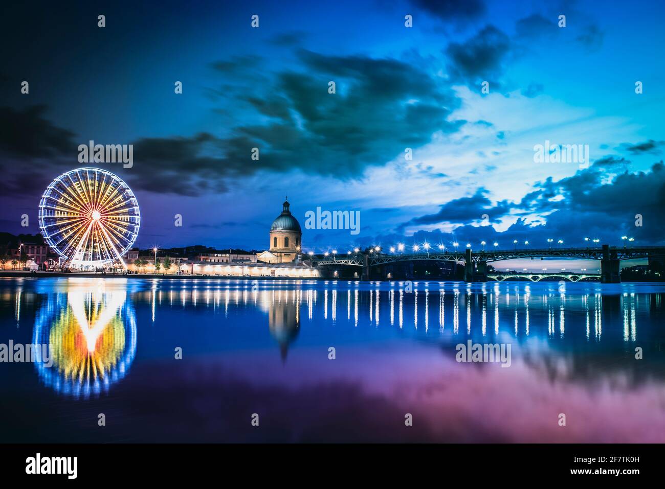 Tolosa, Occitania, Francia; 21 luglio 2018: Tramonto sul fiume Garone con l'ospedale, il ponte di Saint Pierre e la ruota panoramica sull'altro Foto Stock