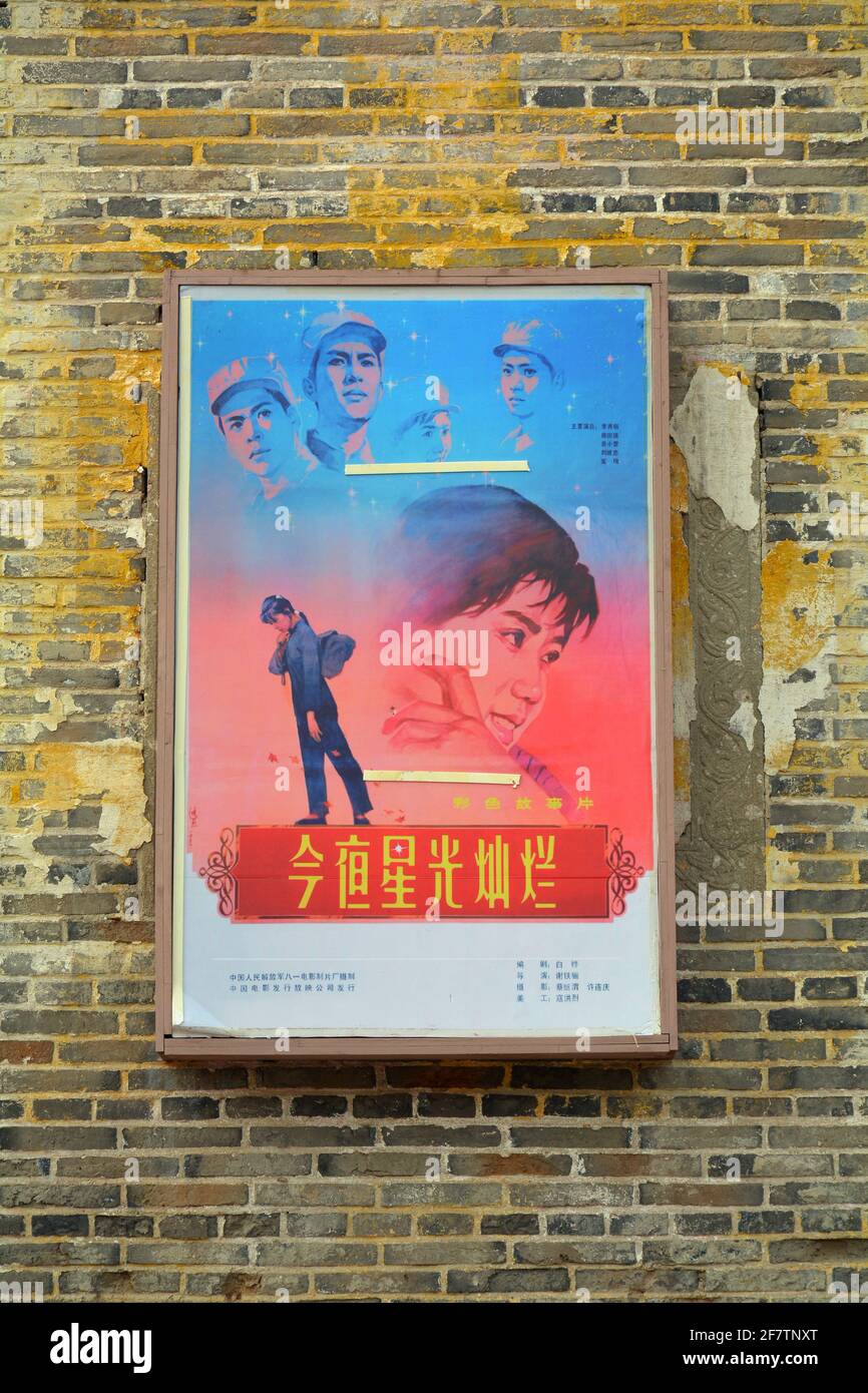 Poster di vecchio stile sul lato esterno di un cinema d'epoca utilizzato per set cinematografici a Xincheng, Cina. Foto Stock