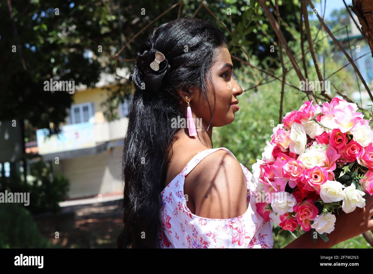 La ragazza con i capelli neri in piedi all'aperto nella bella giornata di sole in Sri Lanka. Foto Stock