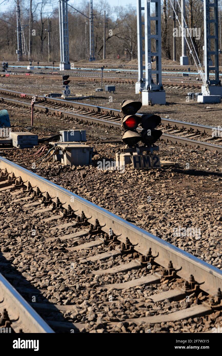 Semaforo luminoso luce rossa tra i binari ferroviari e l'argine di ghiaia primo piano orientamento verticale Foto Stock