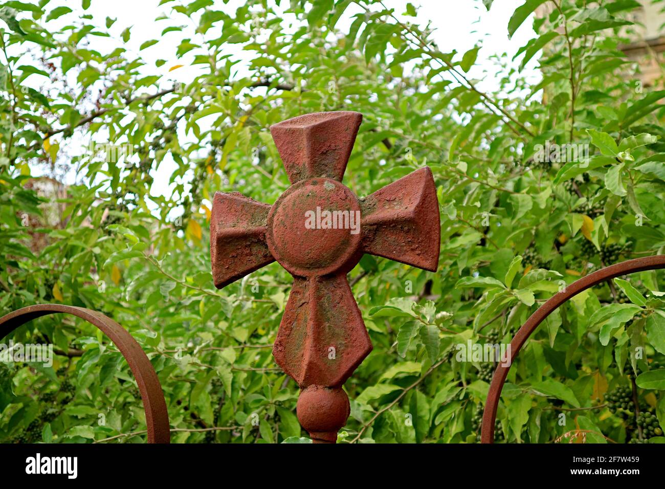 Weated bella croce di una chiesa ortodossa georgiana con verde Fogliame sullo sfondo Foto Stock