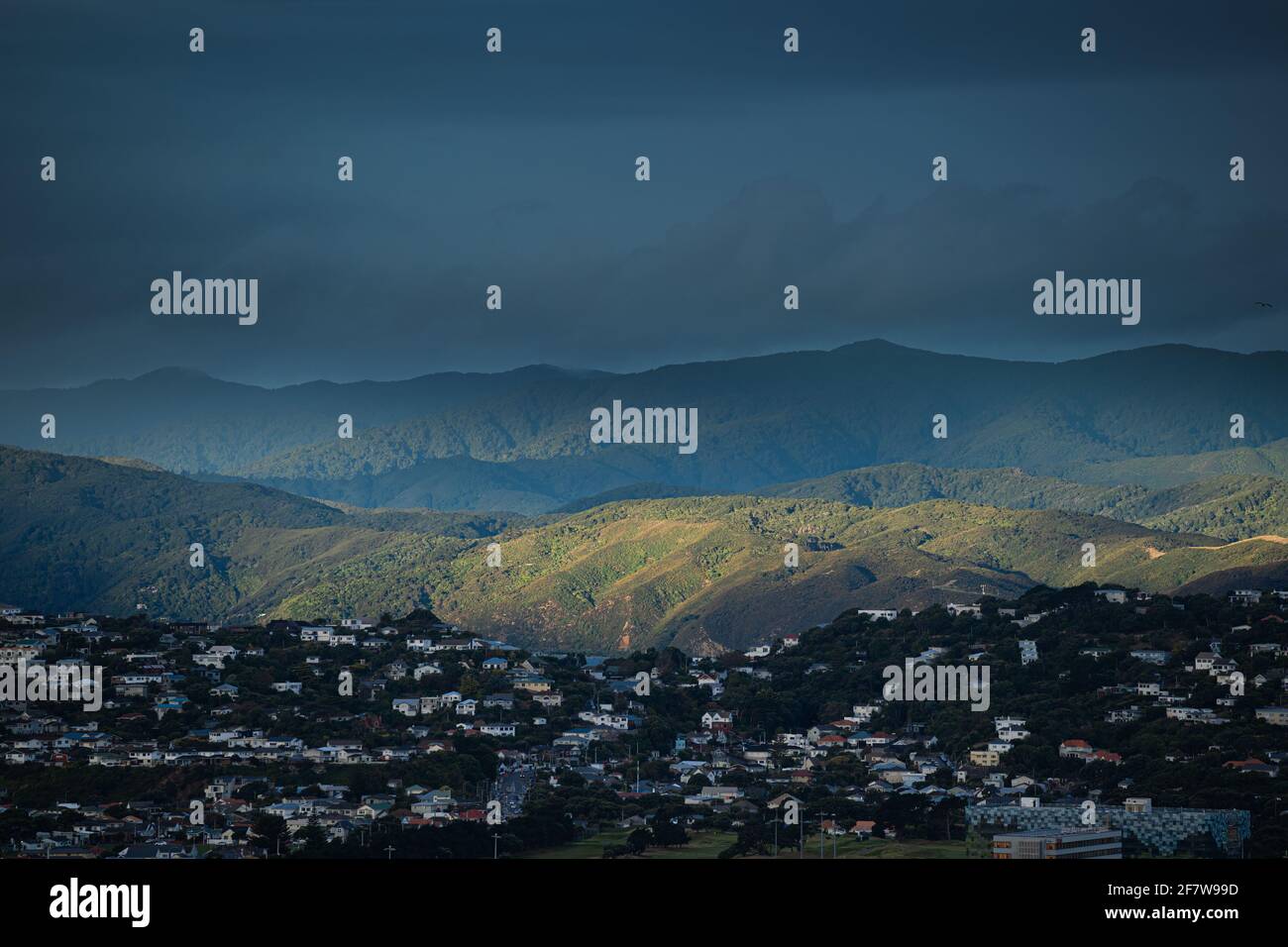 Paesaggio che guarda ad est sopra il sobborgo di Wellington di Miramar, con le montagne del Remutaka Forest Park sullo sfondo e un arcobaleno. Nuova Zelanda. Foto Stock