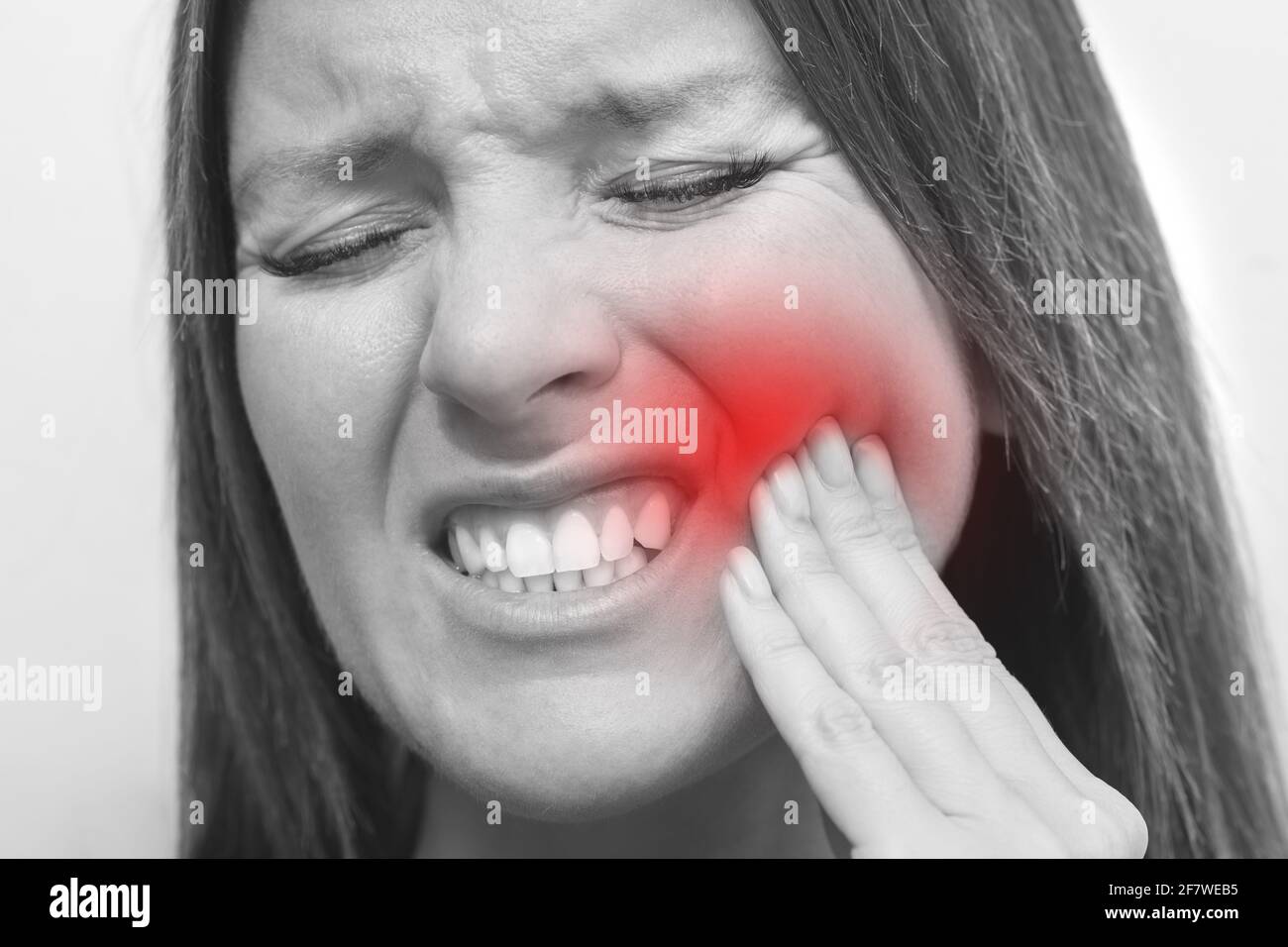 Primo piano del viso della donna con dolore ai denti e dolorosa espressione. Donna che soffre di mal di denti. Sensazione di dolore ai denti da parte delle donne Foto Stock