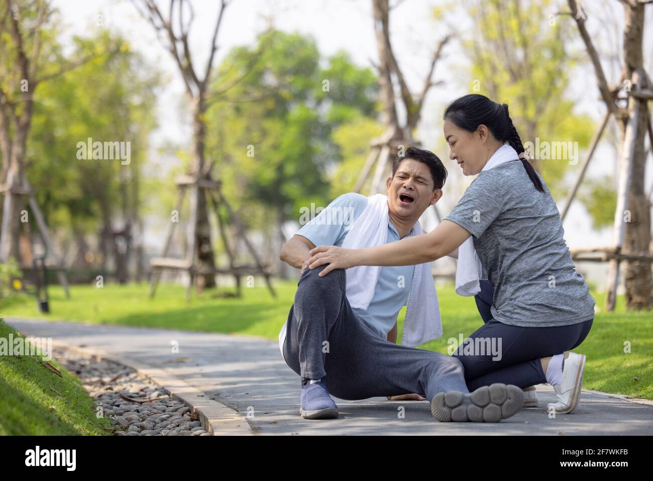 L'anziano asiatico o l'incidente dell'uomo anziano che cade sul pavimento nel parco durante l'esercizio in esecuzione hanno dolore al ginocchio. Foto Stock