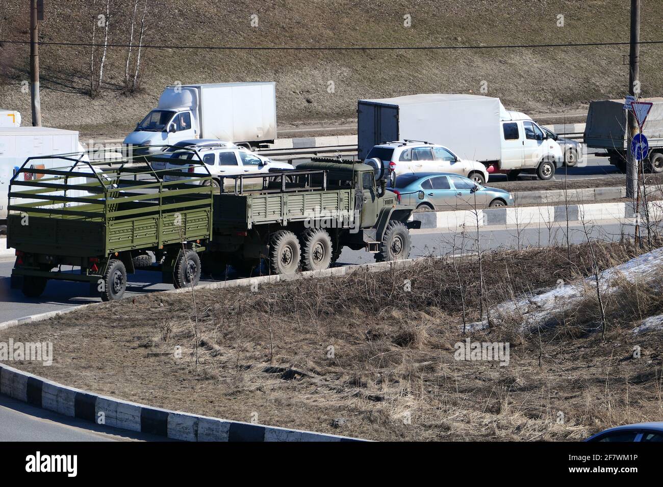 Trasporto di passeggeri e un veicolo militare sulla strada cittadina. Foto Stock