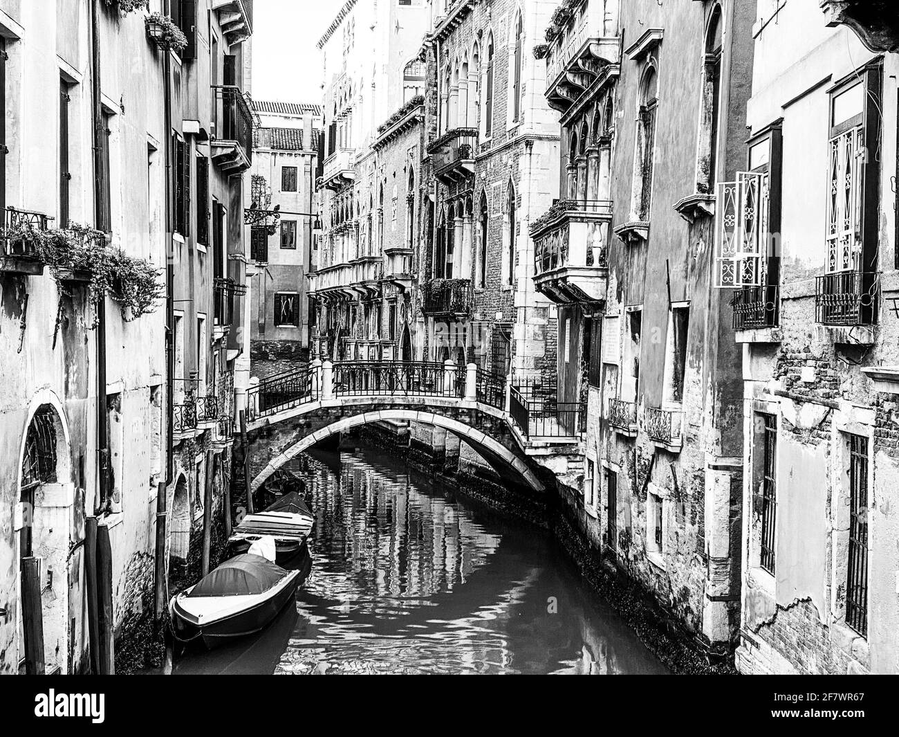 Bel ponte su un piccolo canale fiancheggiato, su sfondo colorato edificio, Venezia, Italia, durante la crisi di Lockdown COVID-19 Foto Stock
