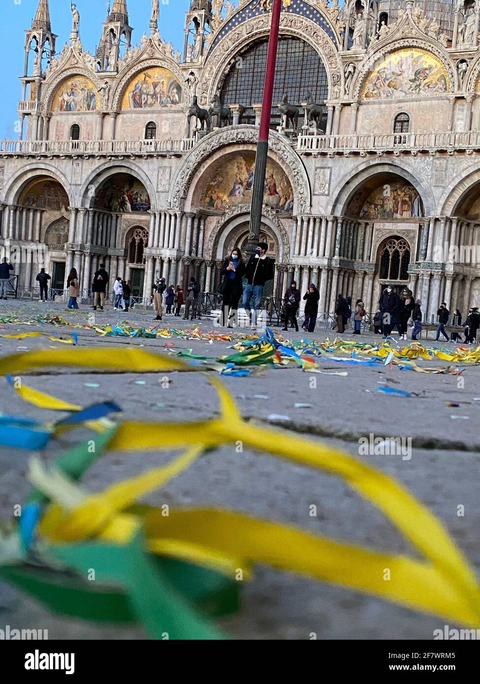 Confetti e carta colorata sul terreno della deserta Piazza San Marco durante il carnevale e la crisi COVID-19, Basilica di San Marco su backgroun Foto Stock