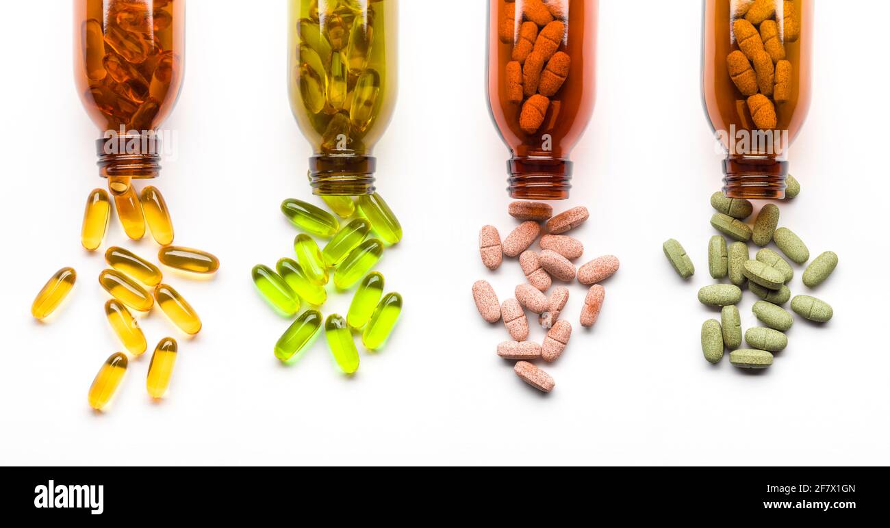 Pillole di supplemento diverse con bottiglie su sfondo bianco Foto Stock
