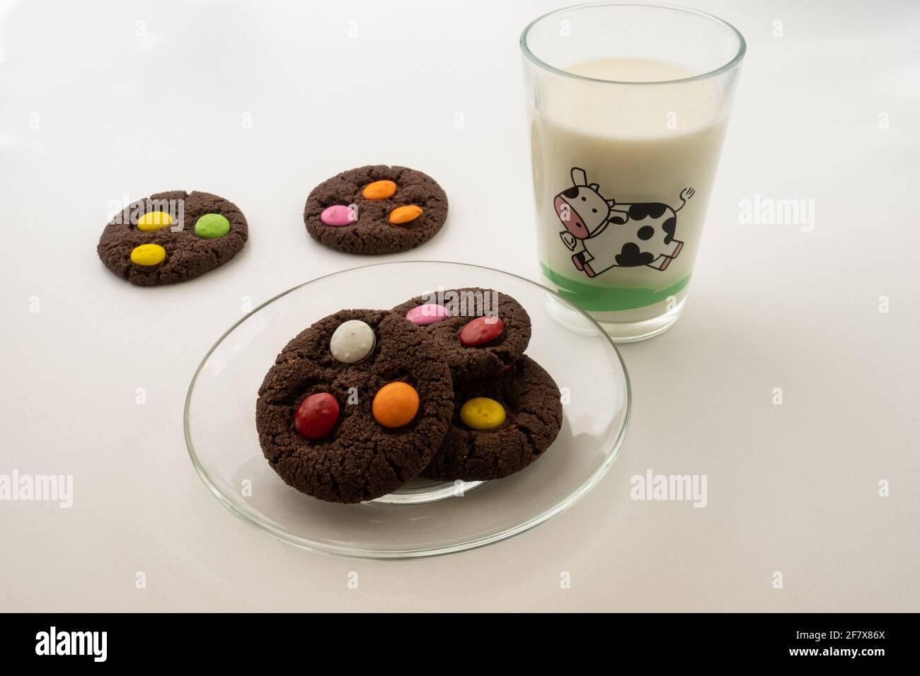 Cookie BonBon con un bicchiere di latte su sfondo bianco Foto Stock