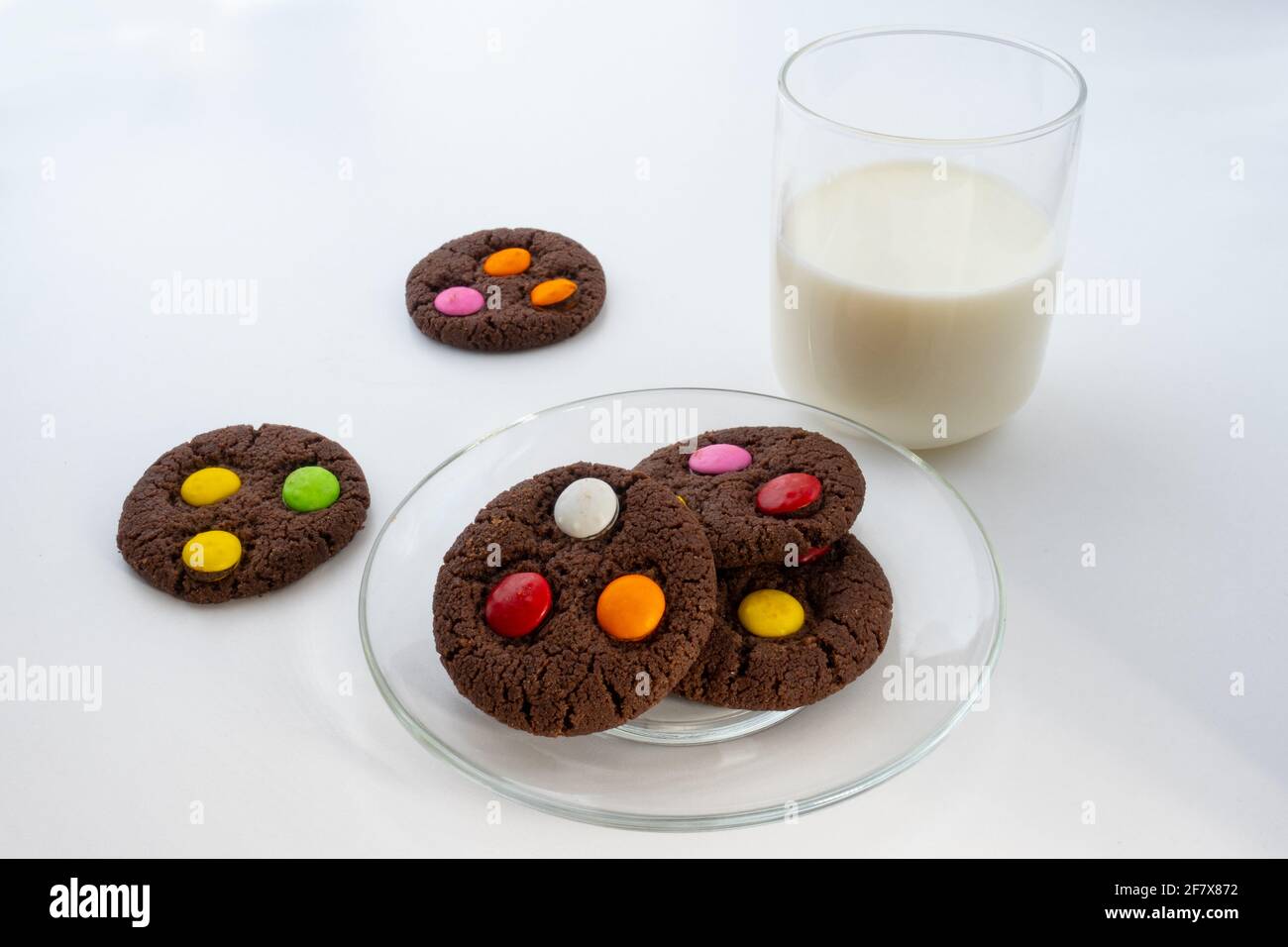 Cookie BonBon con un bicchiere di latte su sfondo bianco Foto Stock